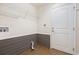 Well-organized laundry room featuring shelving and wainscoting at 10847 Kirkwall Port Dr, Wimauma, FL 33598