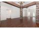 Spacious living room featuring hardwood floors and stylish stone columns with wood beam accents at 10847 Kirkwall Port Dr, Wimauma, FL 33598