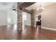 Open floor plan living room featuring wood floors and stone columns with wood beam accents at 10847 Kirkwall Port Dr, Wimauma, FL 33598