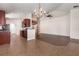 Open concept living room area with wood floors and views to the kitchen with tile floors at 10847 Kirkwall Port Dr, Wimauma, FL 33598