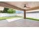 Covered patio with fan overlooks a spacious yard with white fence at 10847 Kirkwall Port Dr, Wimauma, FL 33598