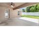View of covered patio with ceiling fan and entry door leading to backyard at 10847 Kirkwall Port Dr, Wimauma, FL 33598