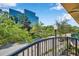 View from the balcony showcasing a modern building, streetscape, and lush trees under a bright sky at 113 S Sherrill St # 113, Tampa, FL 33609