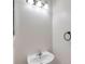Compact half-bathroom features a pedestal sink, black hardware, and textured white walls at 113 S Sherrill St # 113, Tampa, FL 33609