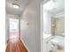 Hallway featuring hardwood floors and an entrance to the bathroom with bathtub and toilet at 113 S Sherrill St # 113, Tampa, FL 33609