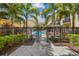 Gated pool area featuring a shared pool, lounge chairs, verdant landscaping and sunny skies at 113 S Sherrill St # 113, Tampa, FL 33609