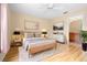 Bright bedroom featuring a queen-sized bed, a ceiling fan, and an ensuite bathroom with cherry wood cabinets at 11546 52Nd E Ct, Parrish, FL 34219