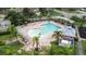 Aerial view of a community pool surrounded by palm trees, pergolas and lounge chairs at 11546 52Nd E Ct, Parrish, FL 34219