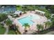 Aerial view of a community pool with splash fountain, surrounded by lounge chairs, picnic tables and tennis courts at 11546 52Nd E Ct, Parrish, FL 34219