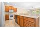 Bright kitchen featuring ceramic tile flooring and wooden cabinets with modern appliances at 11546 52Nd E Ct, Parrish, FL 34219