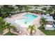 Aerial view of a community pool and recreation area surrounded by lush landscaping and palm trees at 11546 52Nd E Ct, Parrish, FL 34219