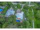 Aerial view of property featuring lush landscaping, private pool, and stylish turquoise accents on the exterior at 1217 N Florida Ave, Tarpon Springs, FL 34689