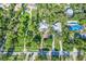 Aerial view of property showing lush landscaping, private pool, and stylish turquoise accents on the exterior at 1217 N Florida Ave, Tarpon Springs, FL 34689