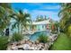 Beautiful backyard with lush landscaping, a sparkling pool, and an inviting patio area at 1217 N Florida Ave, Tarpon Springs, FL 34689