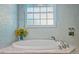 Spa-like bathroom featuring a soaking tub and a decorative window for natural light at 1217 N Florida Ave, Tarpon Springs, FL 34689