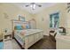 This cozy bedroom features a cottage style bed, natural light and hardwood floors at 1217 N Florida Ave, Tarpon Springs, FL 34689