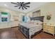 Comfortable bedroom featuring wood floors, a ceiling fan, and serene natural light at 1217 N Florida Ave, Tarpon Springs, FL 34689