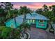 Charming home featuring a brick driveway, tropical landscaping, and beautiful front porch at 1217 N Florida Ave, Tarpon Springs, FL 34689