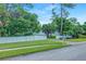 Well-maintained home with a white fence, lush green lawn, and mature trees, offering curb appeal at 1217 N Florida Ave, Tarpon Springs, FL 34689