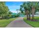 Inviting home featuring a brick driveway, vibrant landscaping, and swaying palm trees at 1217 N Florida Ave, Tarpon Springs, FL 34689