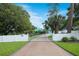 Charming home with gated entrance and a long brick driveway, surrounded by lush greenery and mature trees at 1217 N Florida Ave, Tarpon Springs, FL 34689