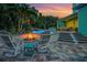 Relaxing backyard fire pit with Adirondack chairs, lush greenery, and evening ambiance at 1217 N Florida Ave, Tarpon Springs, FL 34689