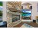 Close-up of the stone fireplace with wooden mantle and inset television and built-in shelves at 1217 N Florida Ave, Tarpon Springs, FL 34689