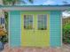Aqua shed with delightful bright green double doors at 1217 N Florida Ave, Tarpon Springs, FL 34689