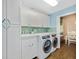 This bright laundry room features shaker style cabinets, modern appliances, and tile details at 1217 N Florida Ave, Tarpon Springs, FL 34689