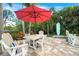 Inviting outdoor patio with dining set, lounge chairs, and lush tropical landscaping at 1217 N Florida Ave, Tarpon Springs, FL 34689