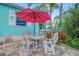 Outdoor dining area on the patio with seating, lush foliage, and colorful tropical plants at 1217 N Florida Ave, Tarpon Springs, FL 34689