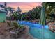 Backyard swimming pool featuring lounge chairs and tropical landscaping at sunset at 1217 N Florida Ave, Tarpon Springs, FL 34689