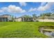 Expansive backyard with lush green grass, pond view, and a screened lanai at 12593 Retreat Pl, Spring Hill, FL 34610