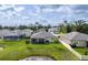 Aerial view showcasing the backyard with pond, lanai, and well-maintained landscaping at 12593 Retreat Pl, Spring Hill, FL 34610