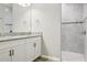 Bathroom with dual sinks, granite countertops, and a tiled walk-in shower at 12593 Retreat Pl, Spring Hill, FL 34610