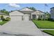 Well-maintained home with a three-car garage, stone accents, and a lush green lawn at 12593 Retreat Pl, Spring Hill, FL 34610
