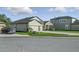 Single-story home featuring a three-car garage, stone accents, and a beautifully maintained green lawn at 12593 Retreat Pl, Spring Hill, FL 34610