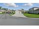 Well-maintained single-story home with a three-car garage, an attractive entryway, and a green lawn at 12593 Retreat Pl, Spring Hill, FL 34610