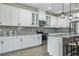 Modern kitchen features white cabinets, gray backsplash, granite countertops, and stainless steel appliances at 12593 Retreat Pl, Spring Hill, FL 34610