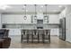 Spacious kitchen features white cabinetry, stainless appliances, granite countertops and an island with seating at 12593 Retreat Pl, Spring Hill, FL 34610