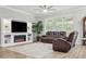 Comfortable living room features an electric fireplace, large window, and two brown leather couches at 12593 Retreat Pl, Spring Hill, FL 34610