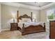 Luxurious main bedroom with wood floors, tray ceiling and a large four-poster bed at 12593 Retreat Pl, Spring Hill, FL 34610