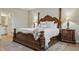 This is the main bedroom featuring a four poster bed, tray ceiling and warm, natural light at 12593 Retreat Pl, Spring Hill, FL 34610