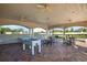 A covered outdoor recreation area with a foosball table and ample seating offers a space to relax and play at 12593 Retreat Pl, Spring Hill, FL 34610