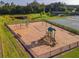 Aerial view of a community playground with swings, slides, and a basketball court surrounded by lush greenery at 12593 Retreat Pl, Spring Hill, FL 34610