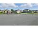 A view of a quiet street showing multiple homes, each with well-kept lawns and attractive landscaping at 12593 Retreat Pl, Spring Hill, FL 34610