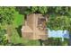 Aerial view of a single-Gathering home with a large yard and mature trees, concrete driveway, and brick walkway at 13094 Huntington Woods Ave, Spring Hill, FL 34609