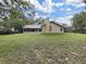 Expansive backyard with a screened-in porch, a brick chimney, and lush greenery; great outdoor space at 13094 Huntington Woods Ave, Spring Hill, FL 34609