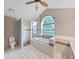 Bright bathroom features a soaking tub under a window, a glass enclosed shower and a water closet at 13094 Huntington Woods Ave, Spring Hill, FL 34609