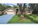 Inviting single-story home with mature trees and a well-manicured lawn at 13094 Huntington Woods Ave, Spring Hill, FL 34609